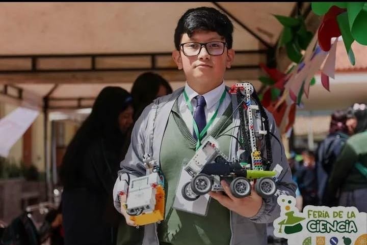 Estudiante mostrando un prototipo robótico escolar